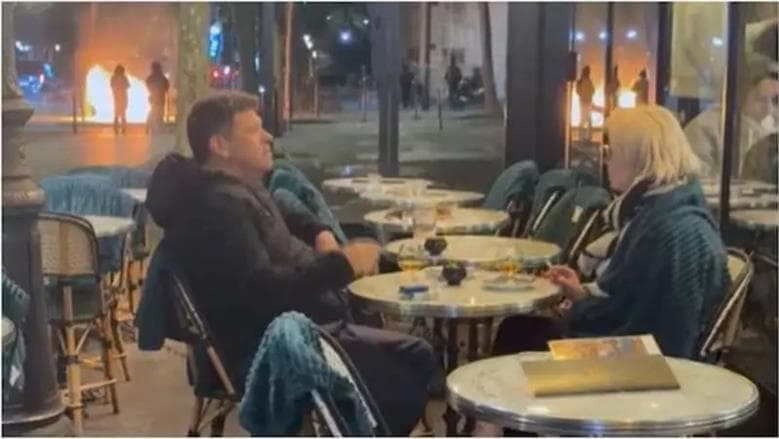 زوجان يتابعان قهوتهما خلال احتجاجات باريس