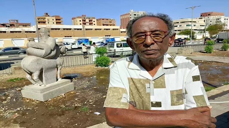 فنان يعبر عن تمثال حصان مقلوب بأسوان