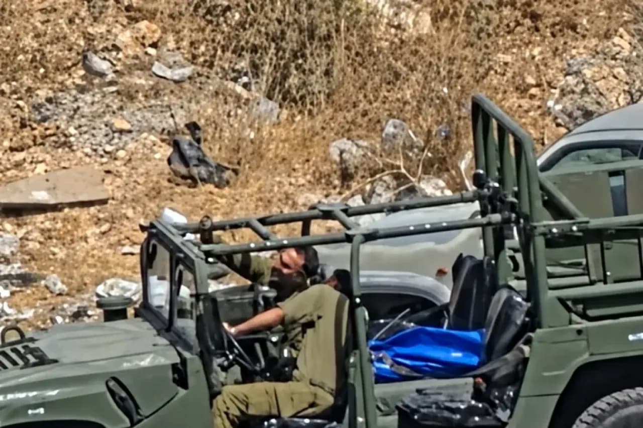 Israeli soldiers pose with Palestinian's body